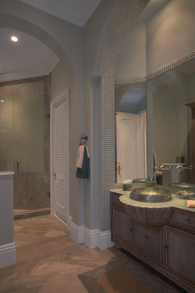 Идея дизайна: большая главная ванная комната в классическом стиле с фасадами островного типа, фасадами цвета дерева среднего тона, душем в нише, плиткой мозаикой, серыми стенами, настольной раковиной, стеклянной столешницей и душем с распашными дверями