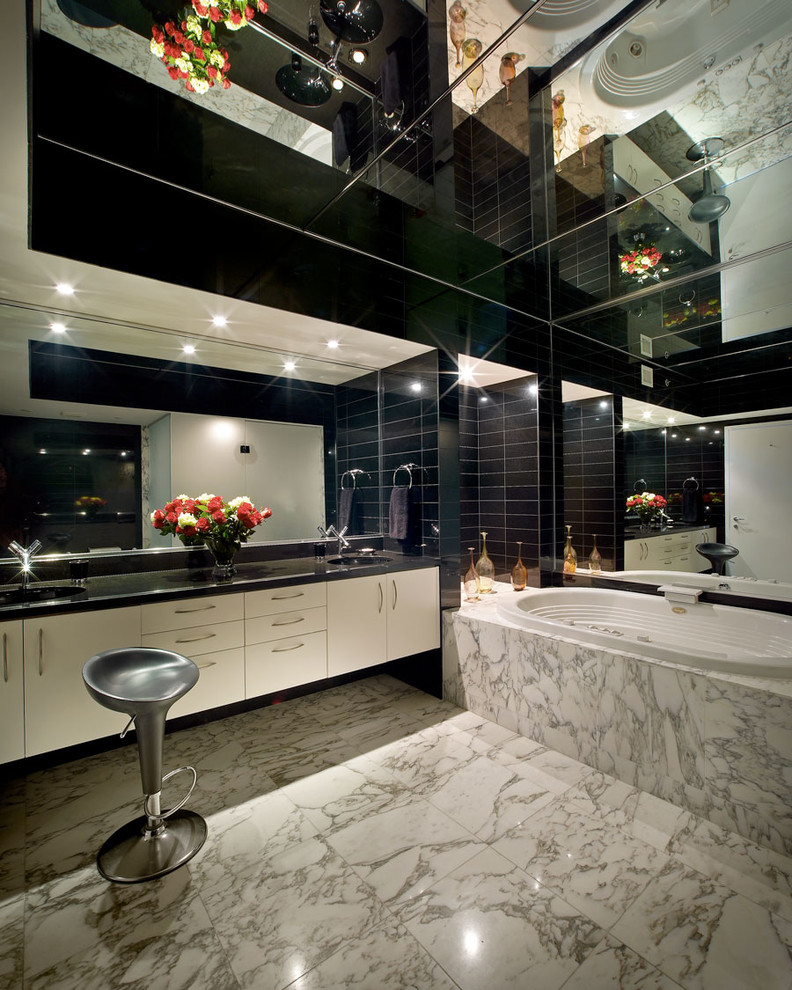 Immagine di una stanza da bagno padronale minimal con ante lisce, ante beige, vasca da incasso, piastrelle nere, pareti nere, pavimento bianco e top nero