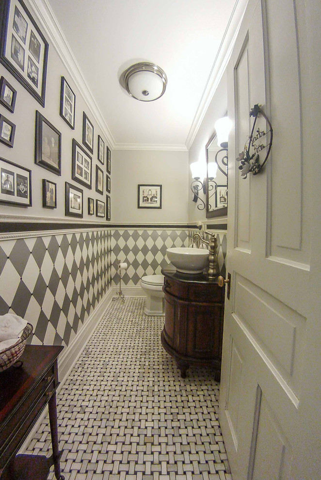 This is an example of a small victorian grey and white ensuite bathroom in Chicago with freestanding cabinets, dark wood cabinets, a two-piece toilet, white tiles, white walls, mosaic tile flooring, a vessel sink, marble worktops, grey floors, brown worktops, a single sink, a freestanding vanity unit, a drop ceiling, wallpapered walls, ceramic tiles and an enclosed toilet.