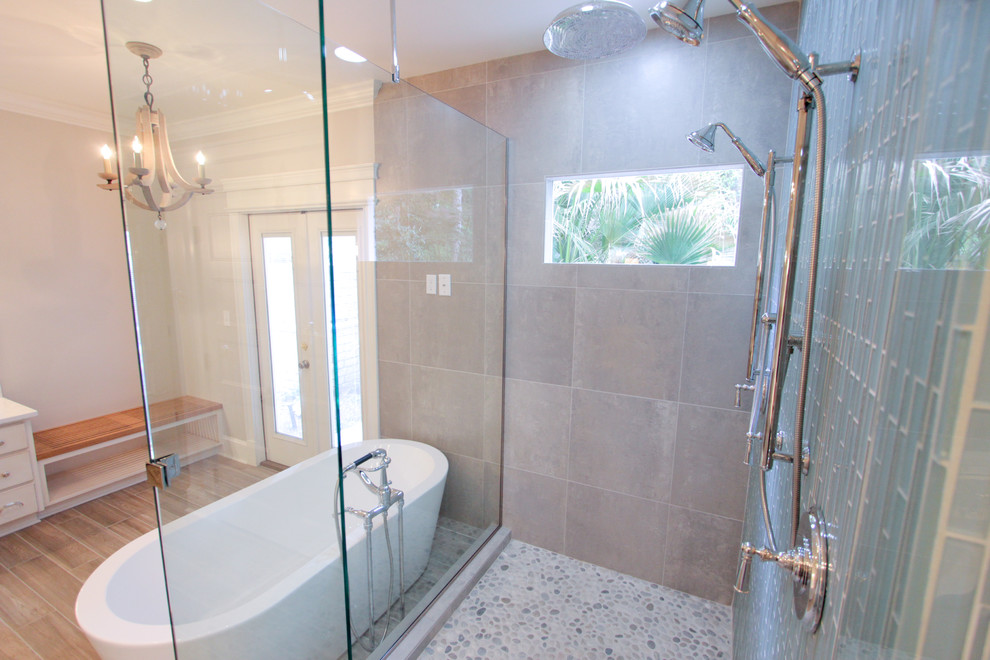 Réalisation d'une salle de bain principale minimaliste de taille moyenne avec un lavabo encastré, un placard à porte plane, des portes de placard beiges, un plan de toilette en marbre, une baignoire indépendante, une douche d'angle, un carrelage en pâte de verre et un mur beige.
