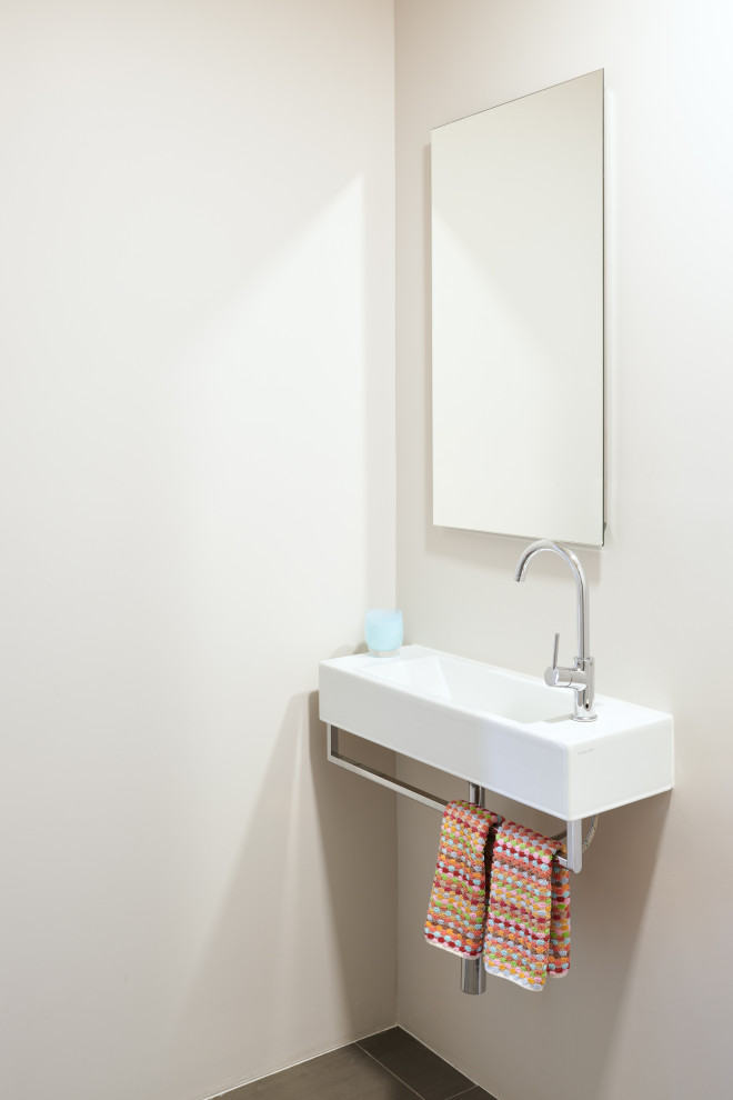 Cette photo montre une petite salle de bain moderne avec un mur blanc, carreaux de ciment au sol, un lavabo suspendu et un sol gris.
