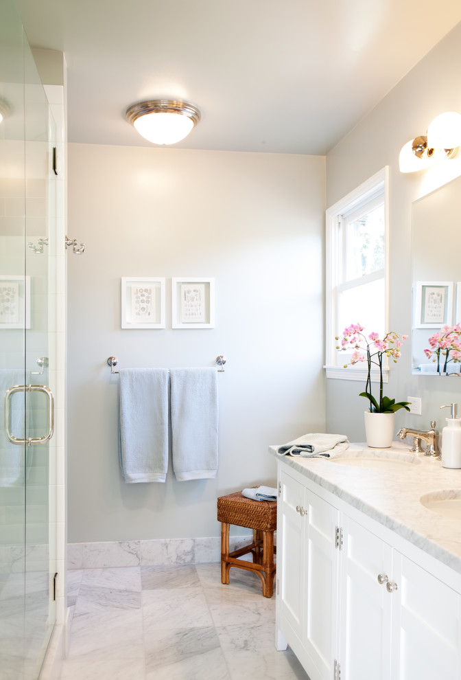 Exemple d'une douche en alcôve chic avec un lavabo encastré, un placard à porte shaker, des portes de placard blanches et un carrelage blanc.