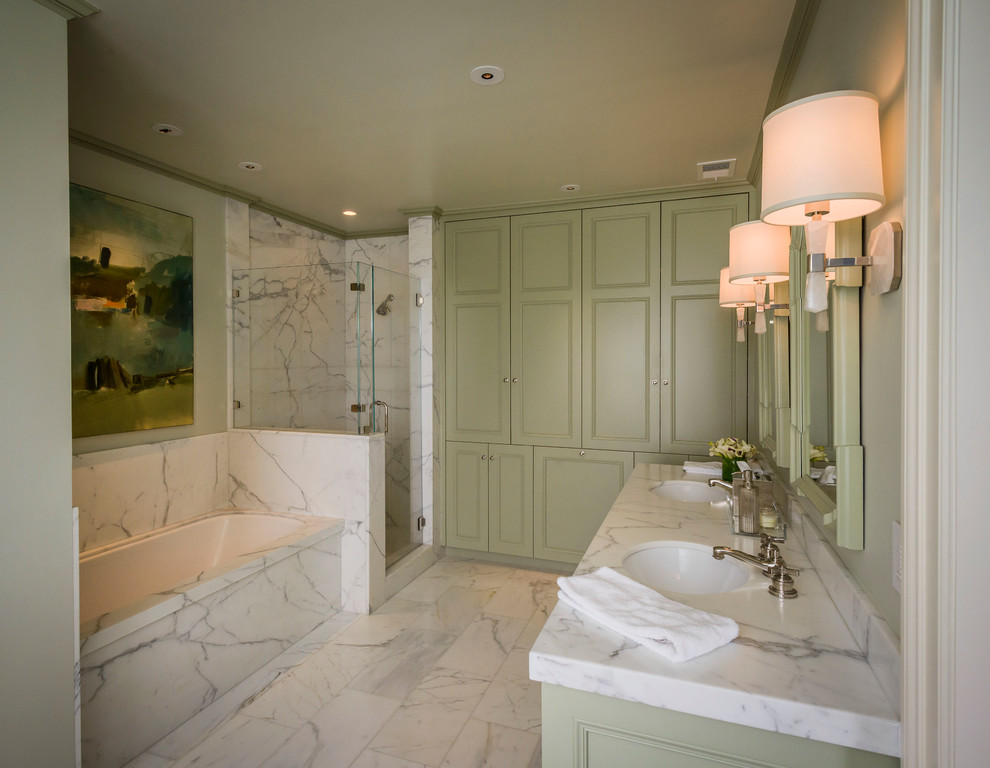 На фото: большая главная ванная комната в классическом стиле с зелеными фасадами, мраморной столешницей, угловым душем, зелеными стенами, полом из керамической плитки, фасадами с декоративным кантом, полновстраиваемой ванной, врезной раковиной и душем с распашными дверями с