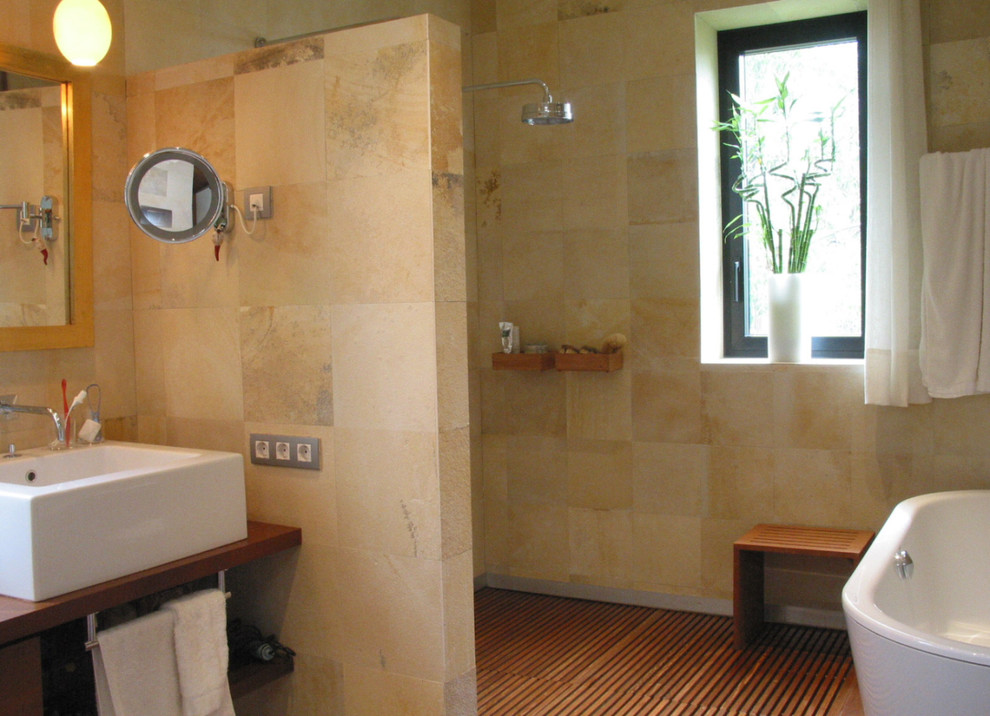 Esempio di una stanza da bagno padronale boho chic di medie dimensioni con ante di vetro, ante beige, top in legno, piastrelle beige, piastrelle in pietra e pareti beige