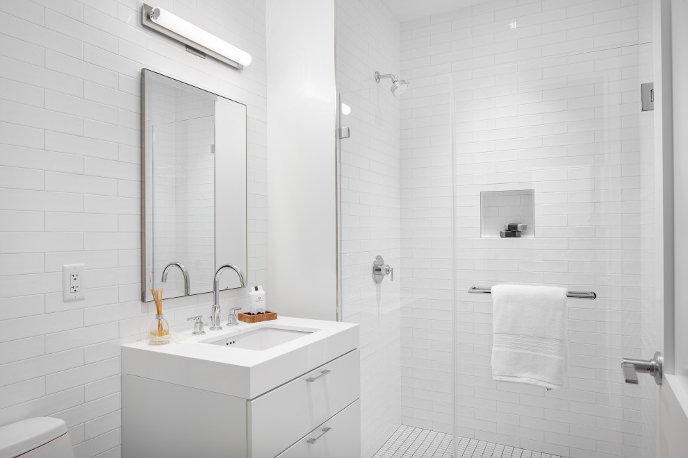 Свежая идея для дизайна: ванная комната среднего размера в современном стиле с плоскими фасадами, белыми фасадами, душем в нише, белой плиткой, плиткой кабанчик, душевой кабиной, врезной раковиной, душем с распашными дверями и белой столешницей - отличное фото интерьера