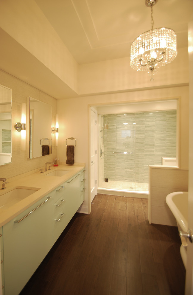 На фото: ванная комната в стиле неоклассика (современная классика) с врезной раковиной, плоскими фасадами, зелеными фасадами, столешницей из известняка, отдельно стоящей ванной и зеленой плиткой с