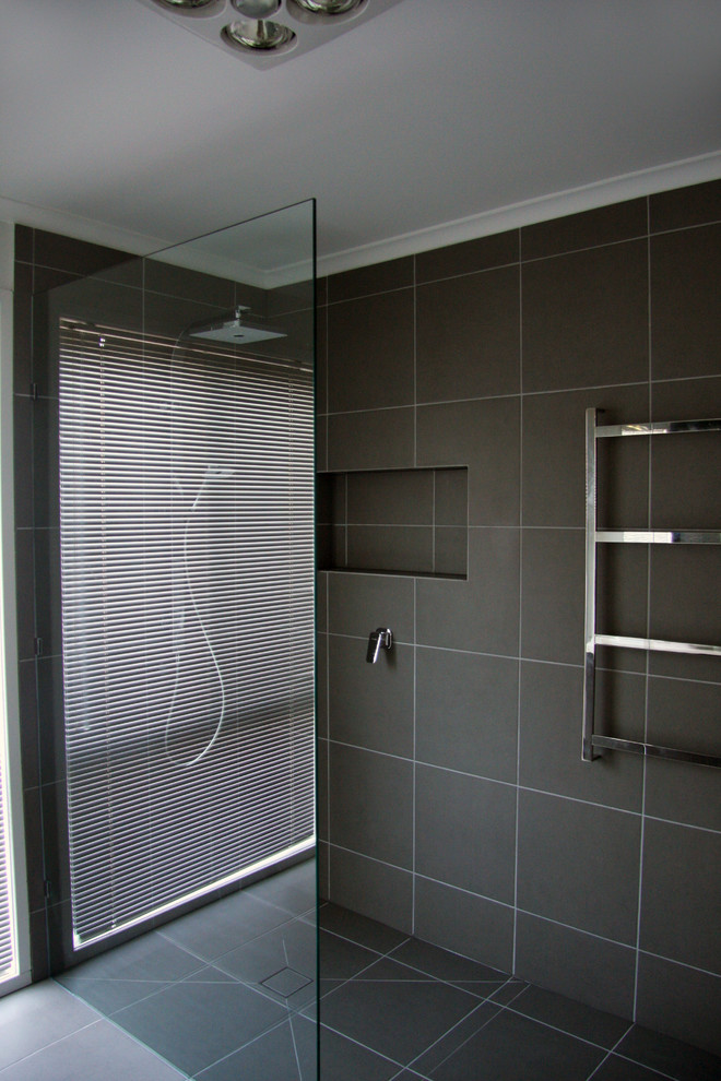 Esempio di una stanza da bagno per bambini minimalista di medie dimensioni con consolle stile comò, ante in legno bruno e top in quarzo composito