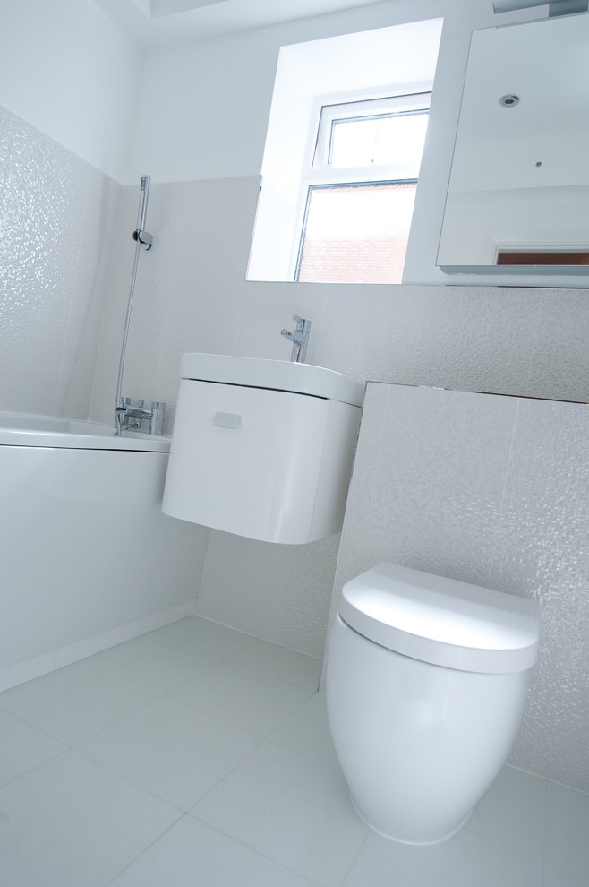 Exempel på ett litet modernt badrum för barn, med ett platsbyggt badkar, en toalettstol med hel cisternkåpa, vit kakel, keramikplattor, vita väggar och en dusch/badkar-kombination