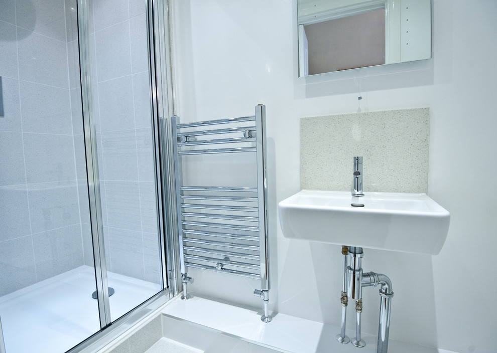Diseño de cuarto de baño contemporáneo pequeño con ducha a ras de suelo, sanitario de una pieza, baldosas y/o azulejos grises, baldosas y/o azulejos de cerámica, paredes blancas, lavabo suspendido y aseo y ducha