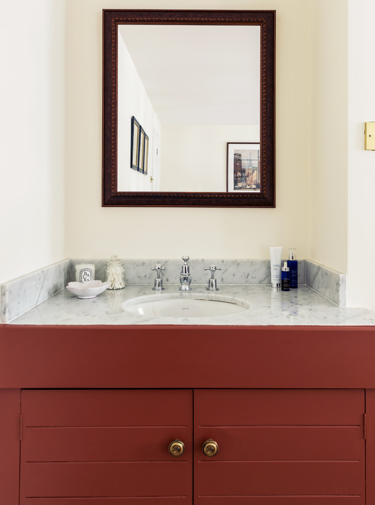 Exempel på ett mellanstort klassiskt badrum, med luckor med profilerade fronter, röda skåp, vit kakel, beige väggar och marmorbänkskiva
