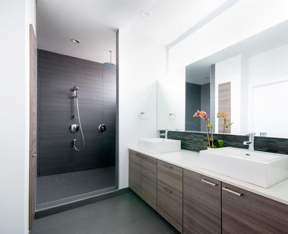 Свежая идея для дизайна: ванная комната в современном стиле с настольной раковиной, плоскими фасадами, столешницей из искусственного кварца, открытым душем, серой плиткой, керамогранитной плиткой, темными деревянными фасадами и открытым душем - отличное фото интерьера