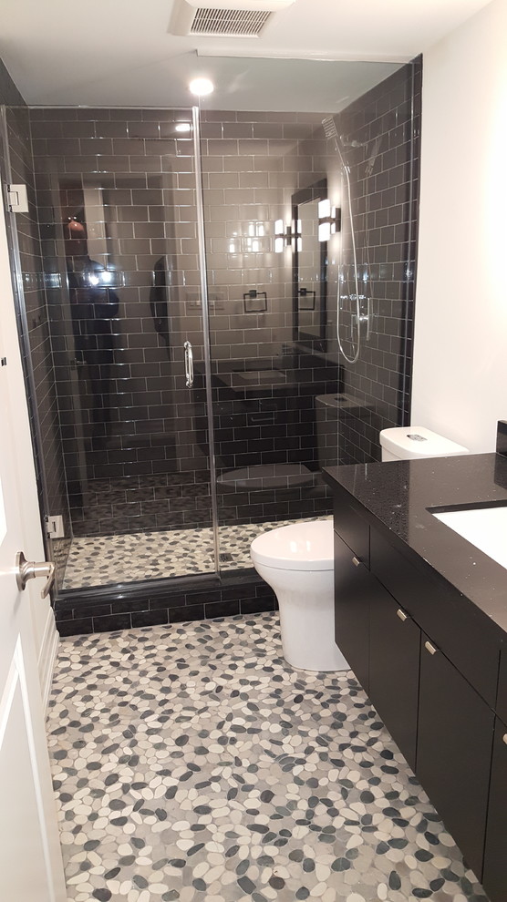 Idéer för mellanstora funkis svart en-suite badrum, med släta luckor, svarta skåp, en dusch i en alkov, vita väggar, ett undermonterad handfat, bänkskiva i kvarts, dusch med gångjärnsdörr, en toalettstol med hel cisternkåpa, klinkergolv i småsten och flerfärgat golv