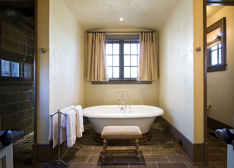 Mid-sized transitional master limestone floor freestanding bathtub photo in Other with beige walls, furniture-like cabinets, an undermount sink, gray cabinets and soapstone countertops