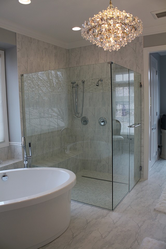Foto på ett mellanstort funkis en-suite badrum, med ett fristående badkar, en kantlös dusch, vit kakel, stenkakel, grå väggar och marmorgolv