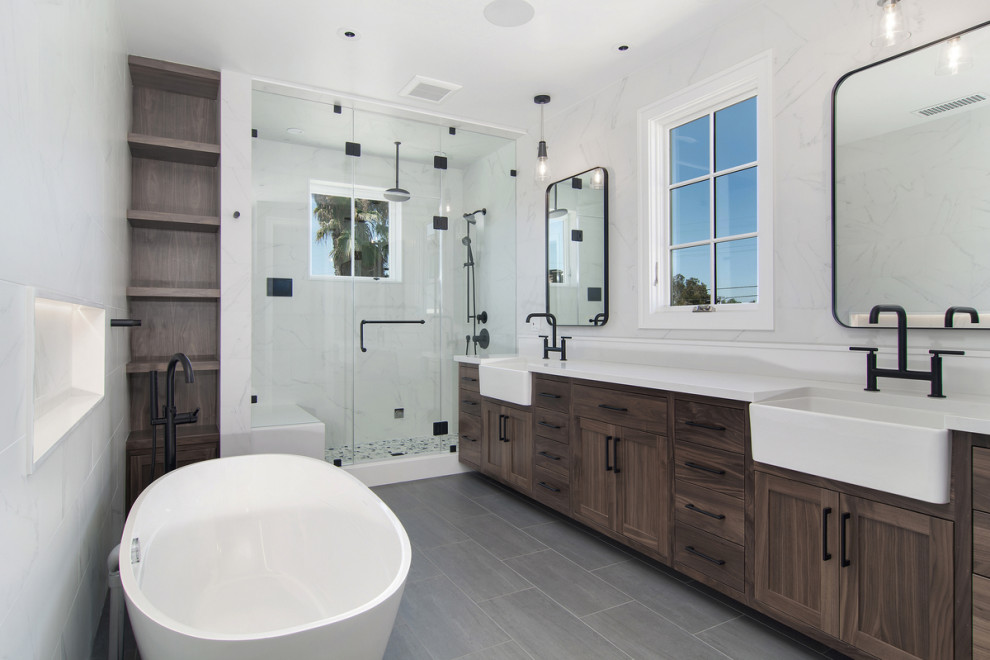 Идея дизайна: главная ванная комната в стиле неоклассика (современная классика) с фасадами в стиле шейкер, темными деревянными фасадами, отдельно стоящей ванной, душем в нише, белой плиткой, белыми стенами, серым полом и белой столешницей