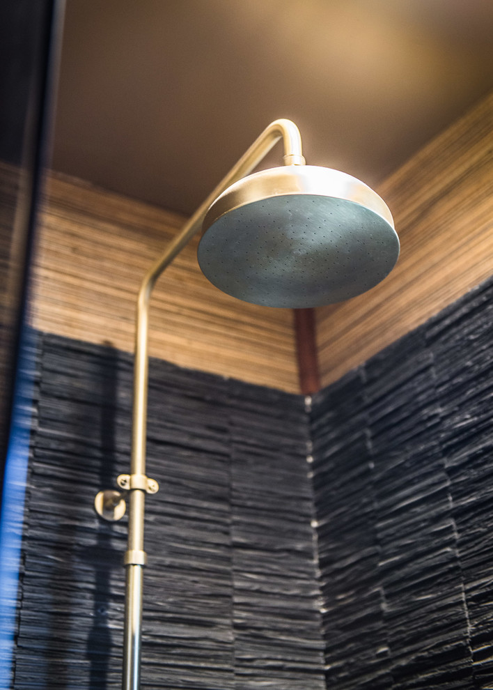 Esempio di una stanza da bagno con doccia minimalista di medie dimensioni con piastrelle nere, pareti beige, parquet chiaro, lavabo a colonna, doccia alcova, WC monopezzo, piastrelle in pietra e top in zinco