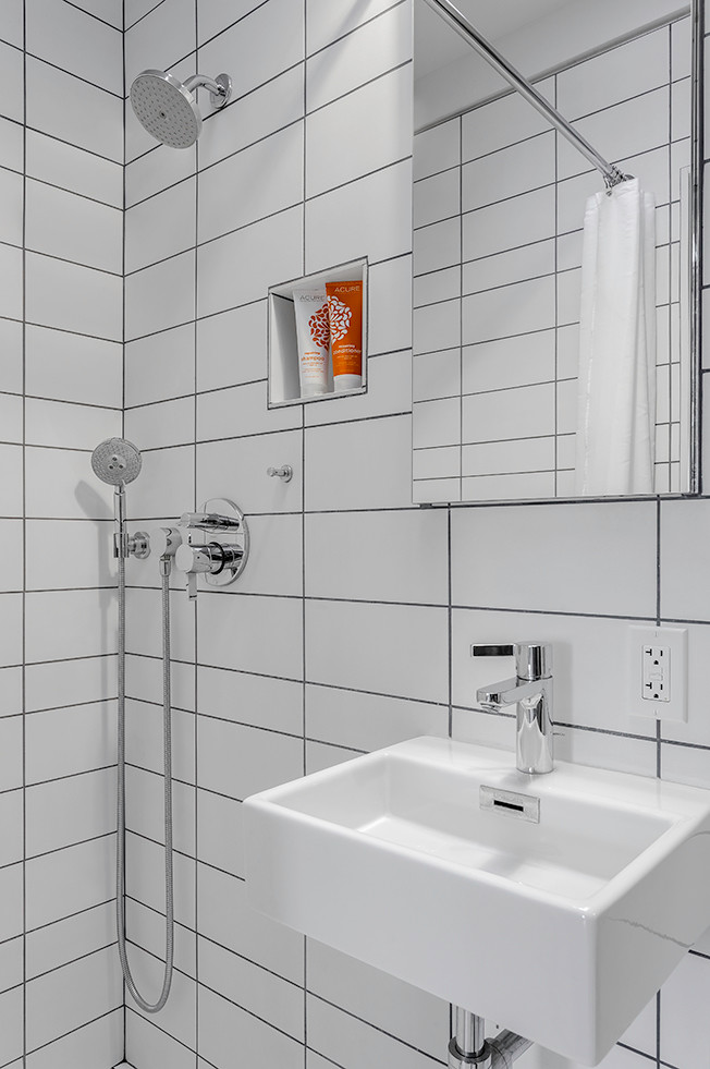 Réalisation d'une salle d'eau minimaliste avec une douche à l'italienne, WC suspendus, un carrelage blanc, des carreaux de céramique, un mur blanc, un sol en carrelage de céramique et un lavabo suspendu.