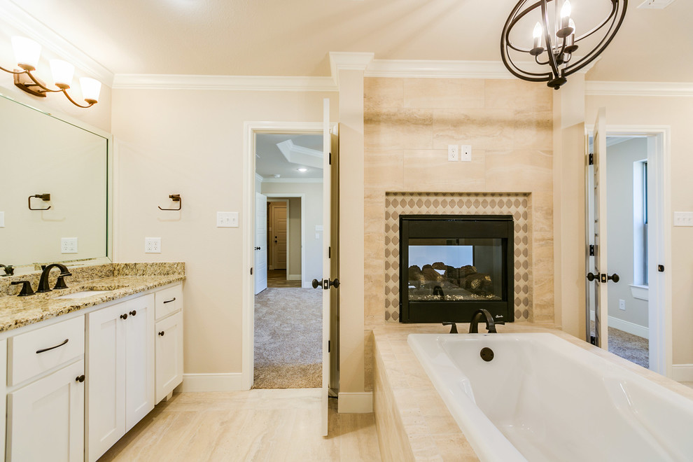 Ispirazione per una grande stanza da bagno padronale chic con ante in stile shaker, ante bianche, vasca da incasso, doccia alcova, WC monopezzo, piastrelle beige, piastrelle in gres porcellanato, pareti beige, pavimento in gres porcellanato, lavabo sottopiano, top in granito, pavimento beige e porta doccia a battente
