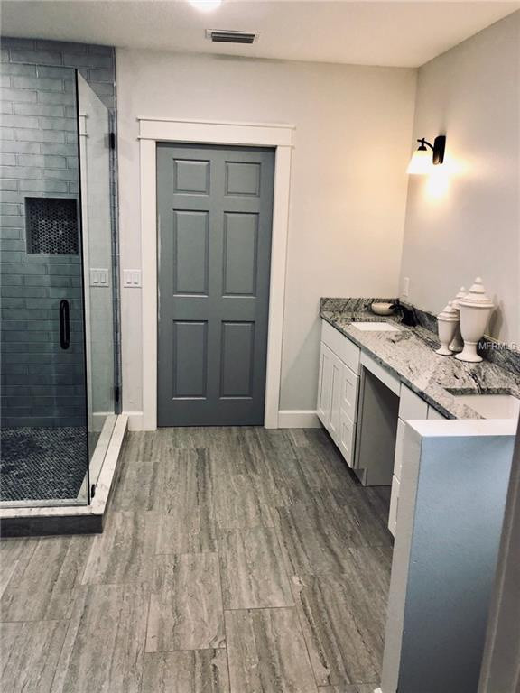 Bild på ett mellanstort 50 tals grå grått en-suite badrum, med skåp i shakerstil, vita skåp och granitbänkskiva