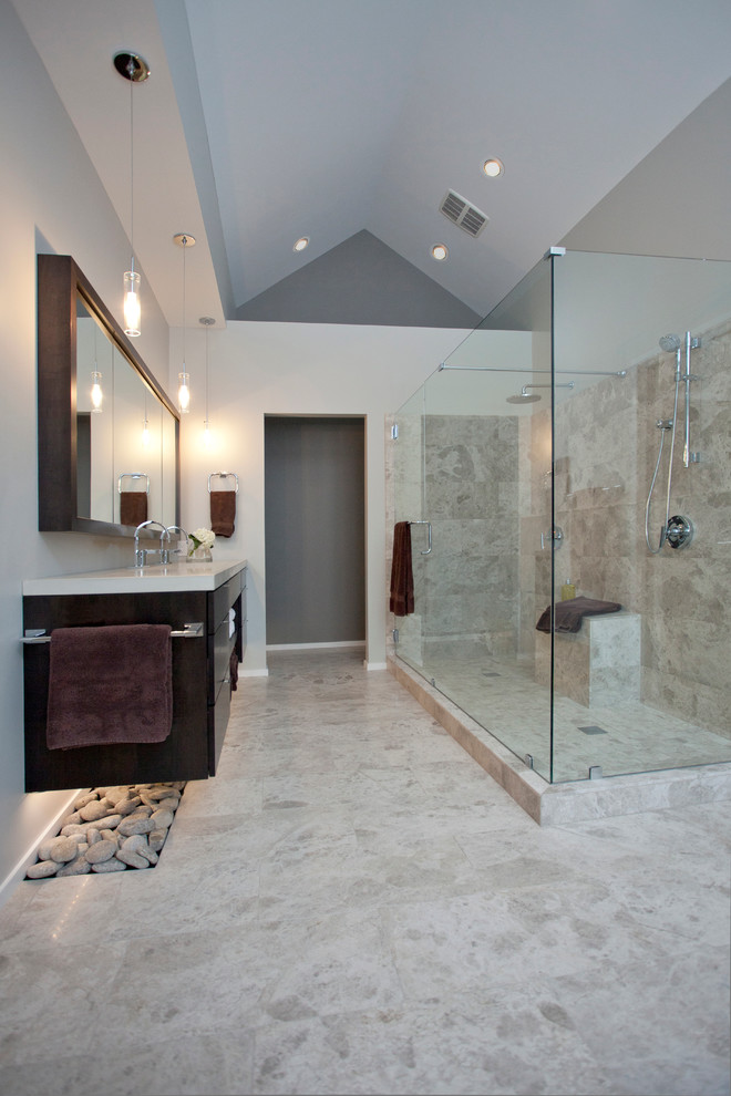 Réalisation d'une salle de bain design en bois foncé avec un placard à porte plane, une douche double, un carrelage beige, un plan de toilette en béton, une baignoire indépendante et du carrelage en pierre calcaire.