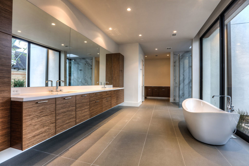 Contemporary bathroom in Houston with flat-panel cabinets, medium wood cabinets, a freestanding bath, grey tiles, white walls, a submerged sink and engineered stone worktops.