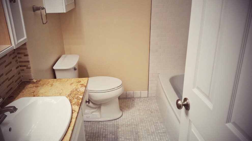 Idéer för att renovera ett litet funkis badrum, med ett nedsänkt handfat, möbel-liknande, vita skåp, bänkskiva i kalksten, ett platsbyggt badkar, en dusch/badkar-kombination, en toalettstol med separat cisternkåpa, beige kakel, mosaik, beige väggar och marmorgolv