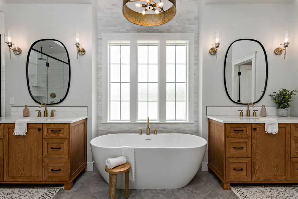 Inredning av ett lantligt vit vitt en-suite badrum, med skåp i shakerstil, skåp i mellenmörkt trä, ett fristående badkar, grå väggar, ett undermonterad handfat, grått golv, grå kakel och stenkakel