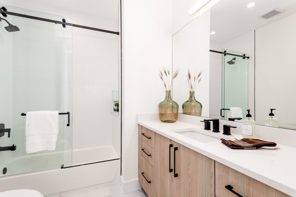 Inredning av ett modernt badrum med dusch, med släta luckor, skåp i mellenmörkt trä, ett badkar i en alkov, en dusch/badkar-kombination, vita väggar, ett undermonterad handfat, bänkskiva i kvarts och dusch med skjutdörr