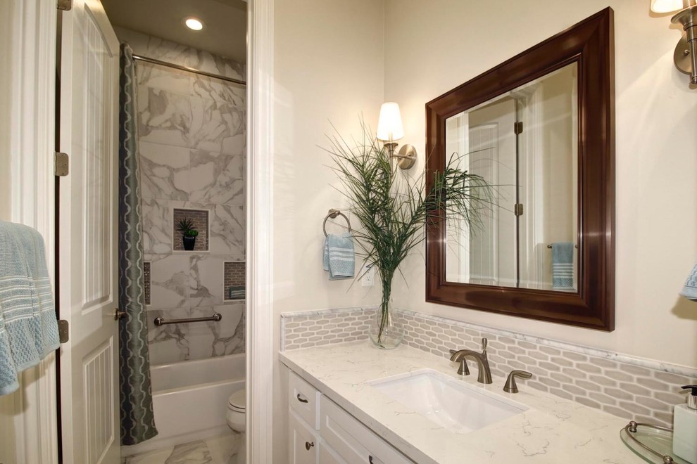 Стильный дизайн: ванная комната среднего размера в классическом стиле с фасадами в стиле шейкер, белыми фасадами, душем над ванной, унитазом-моноблоком, мраморной плиткой, бежевыми стенами, полом из керамической плитки, душевой кабиной, накладной раковиной, столешницей из кварцита, разноцветным полом, шторкой для ванной, белой столешницей, тумбой под одну раковину и встроенной тумбой - последний тренд