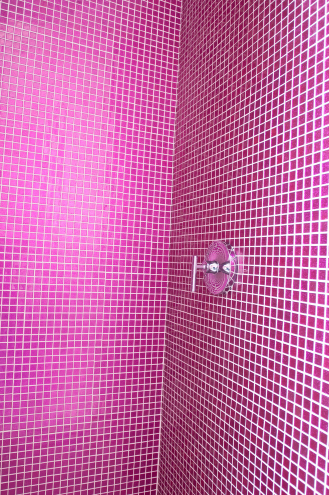 This is an example of a large contemporary family bathroom in New York with open cabinets, a built-in bath, a corner shower, a one-piece toilet, pink tiles, mosaic tiles, pink walls, ceramic flooring, a wall-mounted sink, glass worktops and white floors.