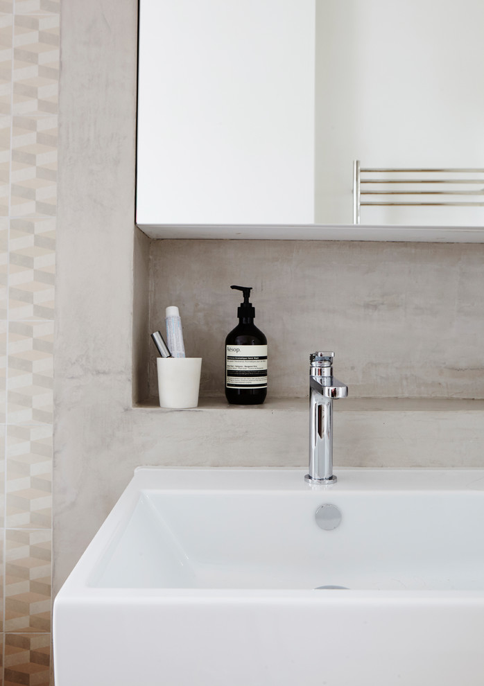 This is an example of a modern bathroom in London with white cabinets, beige tiles, beige walls, a wall-mounted sink and tiled worktops.