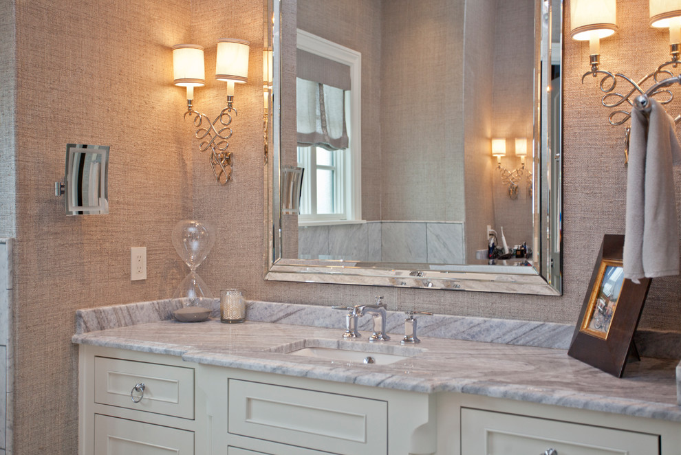 Foto på ett mellanstort vintage beige en-suite badrum, med luckor med infälld panel, vita skåp, ett fristående badkar, beige kakel, marmorkakel, marmorgolv, ett undermonterad handfat, granitbänkskiva och vitt golv