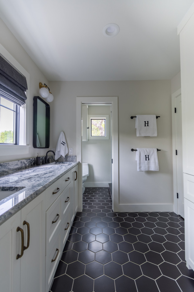 Foto de cuarto de baño clásico renovado con armarios estilo shaker, puertas de armario blancas, paredes blancas, suelo de baldosas de porcelana, suelo negro y encimeras grises