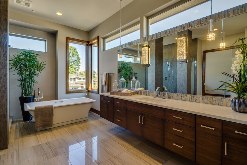 Photo of a large contemporary ensuite bathroom in Portland with a submerged sink, flat-panel cabinets, dark wood cabinets, engineered stone worktops, a freestanding bath, a corner shower, a one-piece toilet, multi-coloured tiles, ceramic tiles, grey walls, limestone flooring and beige floors.