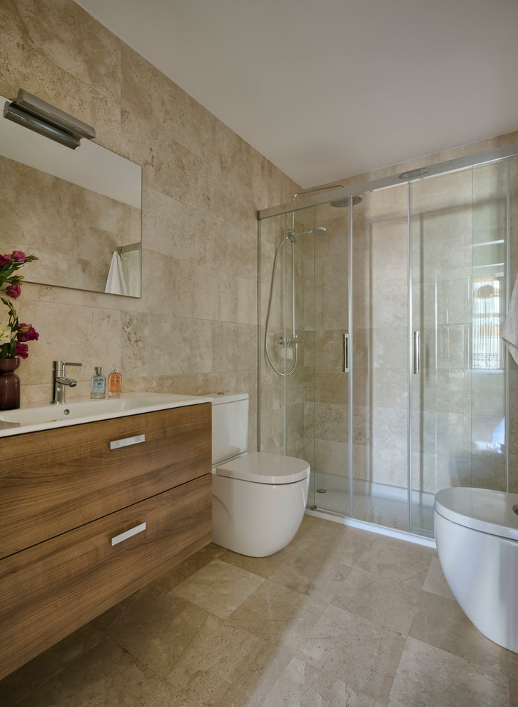 Modelo de cuarto de baño bohemio de tamaño medio con armarios con paneles lisos, puertas de armario de madera oscura, ducha empotrada, bidé, paredes beige, aseo y ducha y lavabo integrado