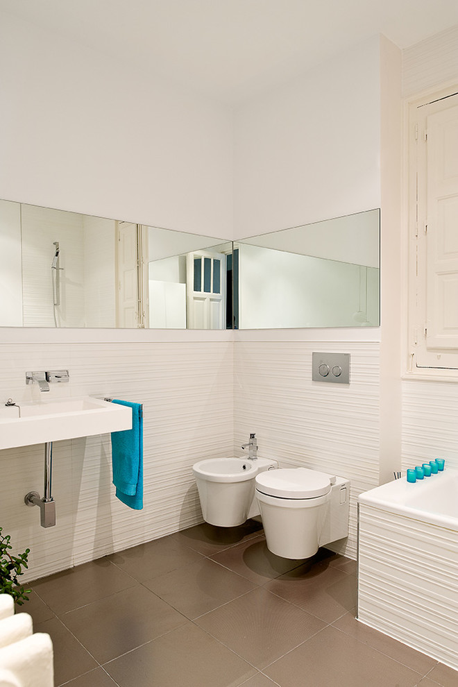 Foto di una stanza da bagno padronale design di medie dimensioni con lavabo sospeso, WC sospeso, piastrelle bianche, pareti bianche, pavimento con piastrelle in ceramica e vasca da incasso