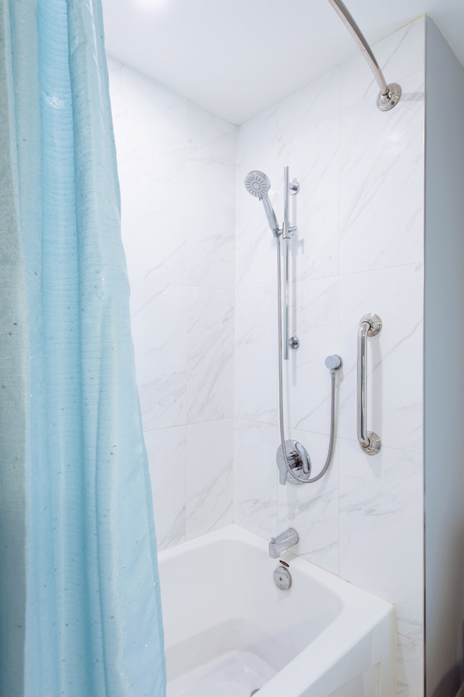 Inredning av ett lantligt mellanstort vit vitt badrum med dusch, med skåp i shakerstil, vita skåp, ett badkar i en alkov, en dusch/badkar-kombination, en toalettstol med hel cisternkåpa, vit kakel, porslinskakel, blå väggar, vinylgolv, ett undermonterad handfat, bänkskiva i glas, grått golv och dusch med duschdraperi