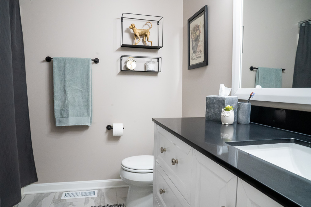 Foto på ett mellanstort vintage svart badrum, med möbel-liknande, vita skåp, en dusch/badkar-kombination, en toalettstol med hel cisternkåpa, beige väggar, klinkergolv i keramik, ett undermonterad handfat, granitbänkskiva, flerfärgat golv och dusch med duschdraperi