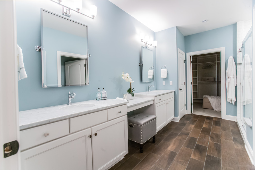 Klassisk inredning av ett stort en-suite badrum, med luckor med infälld panel, vita skåp, ett undermonterad handfat, en dusch i en alkov, vit kakel, tunnelbanekakel, marmorbänkskiva, bruna väggar, klinkergolv i porslin, brunt golv och dusch med skjutdörr