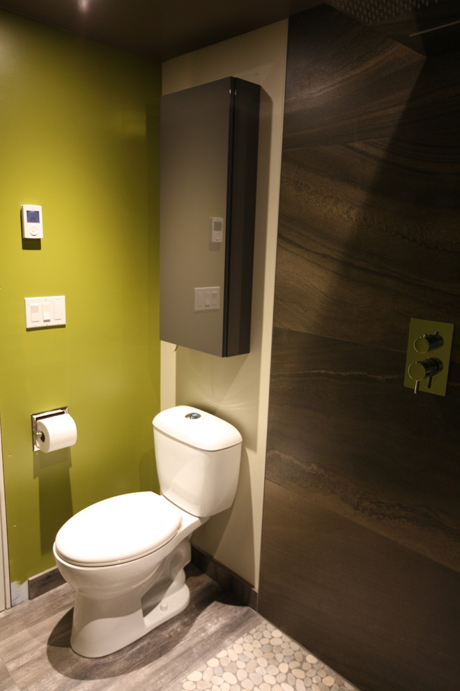 Design ideas for a small modern cloakroom in Edmonton with flat-panel cabinets, grey cabinets, a two-piece toilet, brown tiles, porcelain tiles, green walls, porcelain flooring, an integrated sink, solid surface worktops and grey floors.