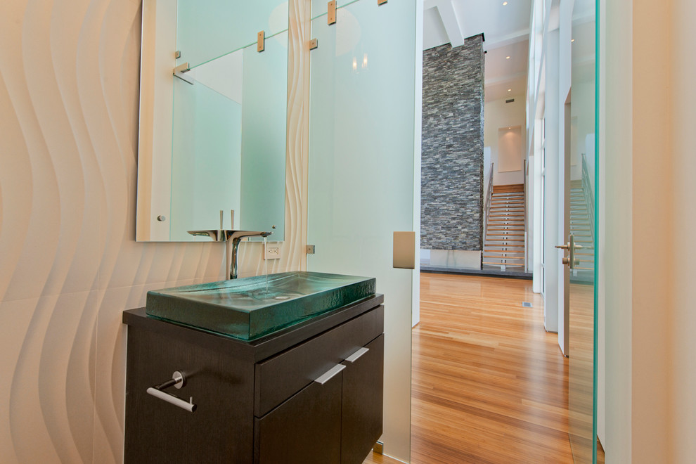 На фото: ванная комната среднего размера в стиле модернизм с настольной раковиной, плоскими фасадами, темными деревянными фасадами, стеклянной столешницей, белой плиткой, керамогранитной плиткой, белыми стенами и полом из бамбука