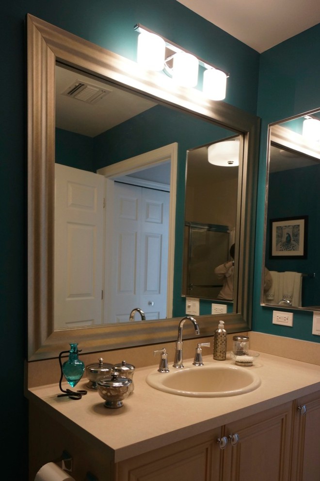 Kleines Klassisches Badezimmer mit Einbauwaschbecken, Kassettenfronten, hellen Holzschränken, Laminat-Waschtisch, Wandtoilette mit Spülkasten, blauer Wandfarbe und Keramikboden in New York