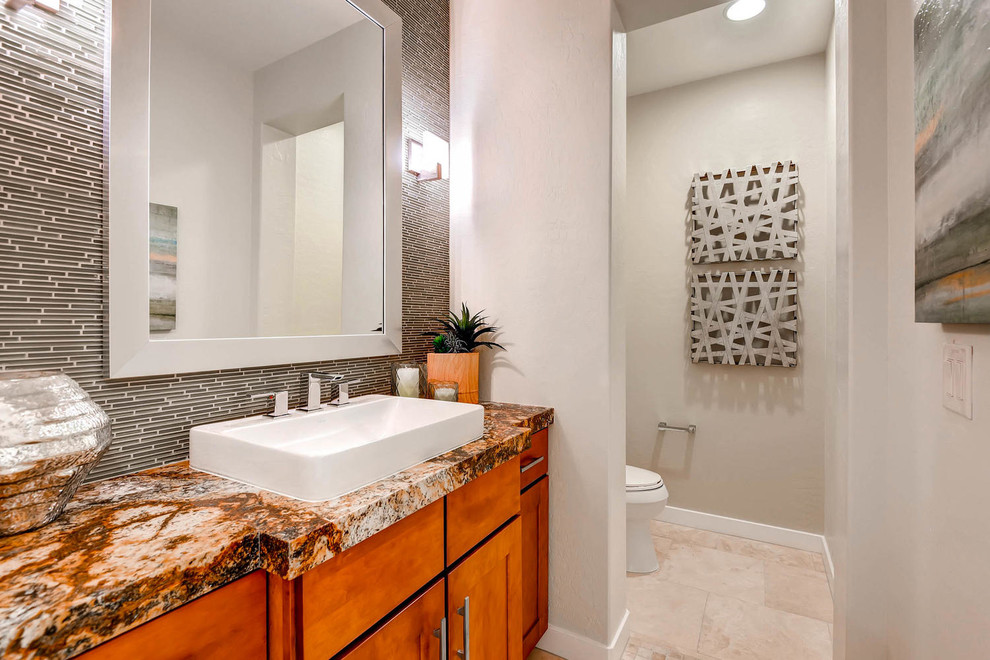 Medium sized classic ensuite bathroom in Las Vegas with shaker cabinets, medium wood cabinets, a one-piece toilet, beige tiles, glass tiles, beige walls, ceramic flooring, a vessel sink and granite worktops.