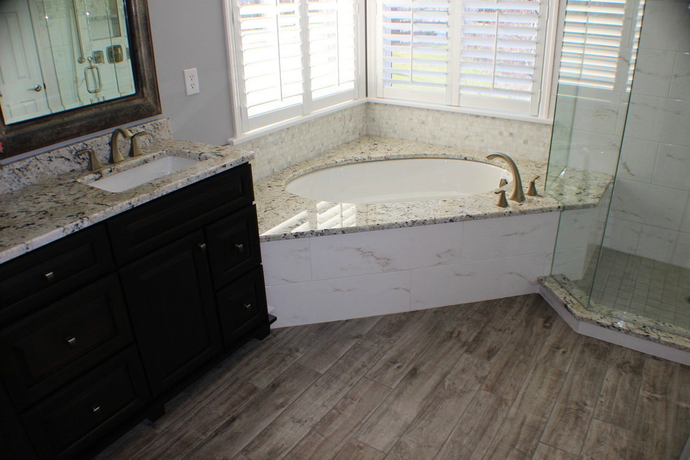 Klassisk inredning av ett mellanstort en-suite badrum, med vit kakel, grå väggar, ett undermonterat badkar, en hörndusch, marmorkakel, mörkt trägolv, brunt golv och dusch med gångjärnsdörr