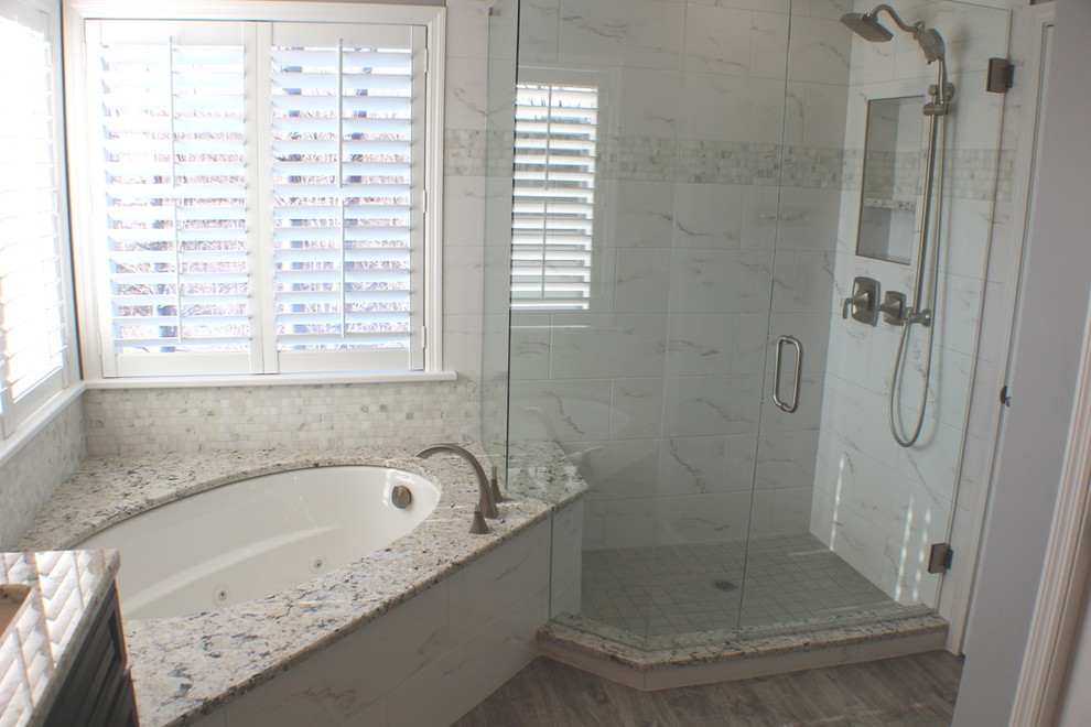 На фото: главная ванная комната среднего размера в стиле неоклассика (современная классика) с белой плиткой, серыми стенами, полновстраиваемой ванной, угловым душем, мраморной плиткой, темным паркетным полом, коричневым полом и душем с распашными дверями