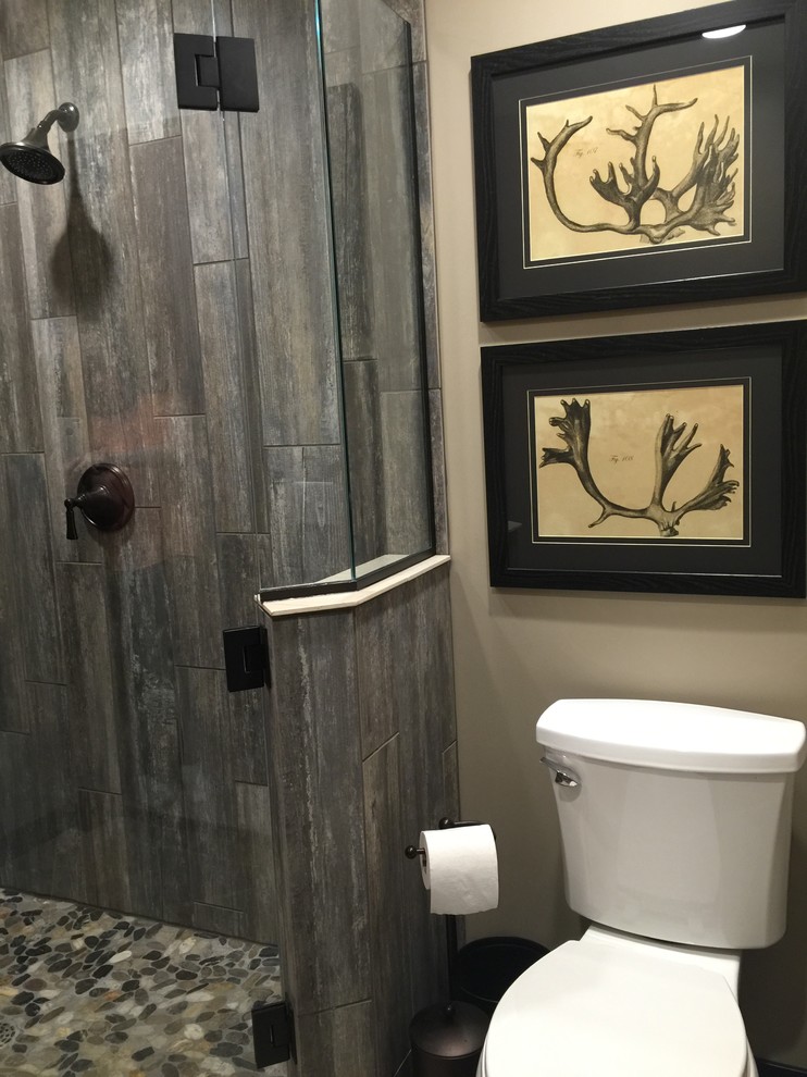 Inspiration for a small rustic 3/4 gray tile and pebble tile ceramic tile corner shower remodel in Other with an undermount sink, furniture-like cabinets, dark wood cabinets, quartz countertops, a one-piece toilet and beige walls