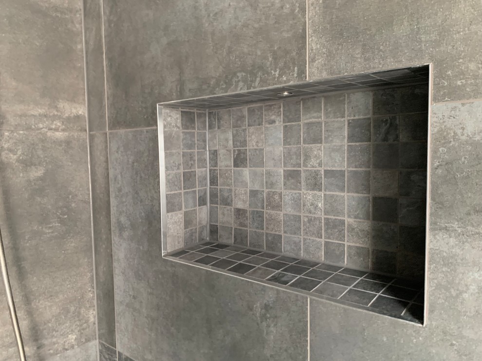 Cette image montre une salle de bain principale design avec une baignoire en alcôve, une douche ouverte, WC à poser, un carrelage gris, mosaïque, un mur gris, carreaux de ciment au sol, un lavabo suspendu, un plan de toilette en carrelage, un sol gris, une cabine de douche à porte battante et un plan de toilette gris.