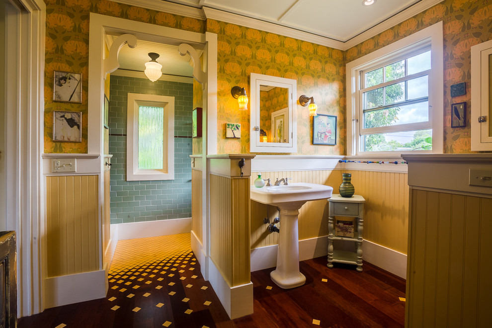 Amerikansk inredning av ett mellanstort en-suite badrum, med gula väggar, mörkt trägolv, ett piedestal handfat, grön kakel och tunnelbanekakel