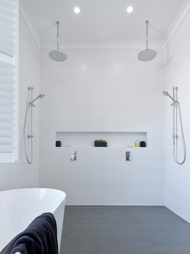 На фото: главная ванная комната среднего размера в современном стиле с белыми фасадами, отдельно стоящей ванной, открытым душем, раздельным унитазом, белой плиткой, керамогранитной плиткой, белыми стенами, полом из керамогранита, настольной раковиной, серым полом и открытым душем