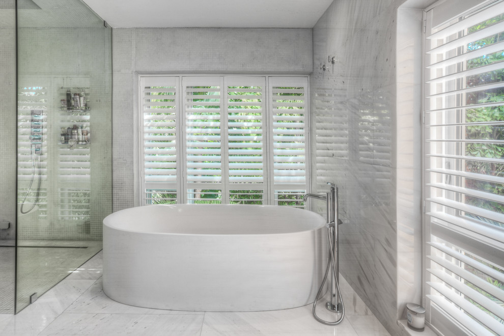 На фото: большая главная ванная комната в современном стиле с отдельно стоящей ванной, угловым душем, белыми стенами и полом из керамогранита